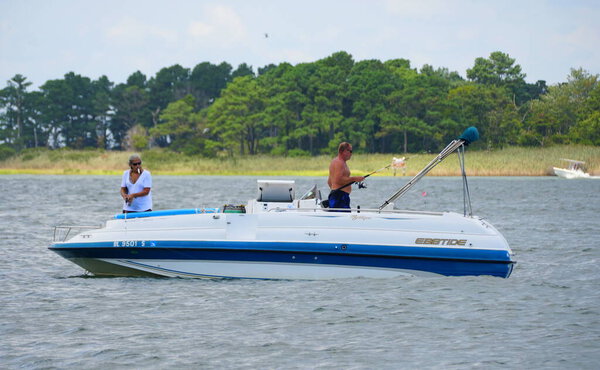 Bethany Beach, Делавэр, США - September 2, 2019 - Anglers on the boat fishing for flounder near Indian River Inlet in the summer
