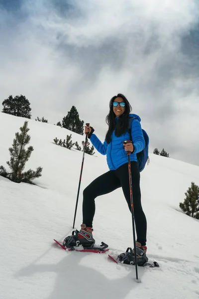 Mujer joven con raquetas de nieve en alta montaña — Foto de Stock