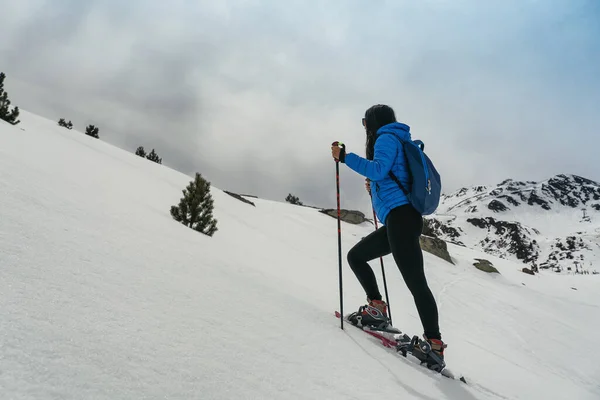 Mujer joven caminando con raquetas de nieve en alta montaña — Foto de Stock