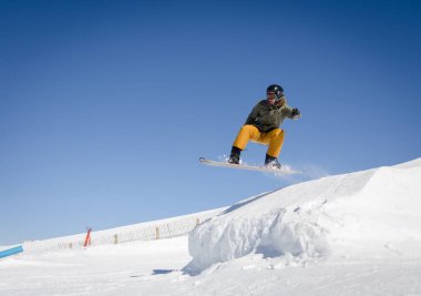 Zermatt 'ta mavi ve güneşli bir gökyüzü olan snowboardcu, İsviçre Alpleri