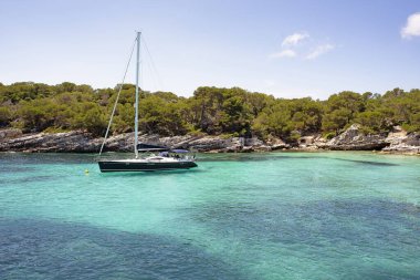 Menorca Adası, Akdeniz, İspanya 'da Cala Macarelleta' da bir yat duruyor.