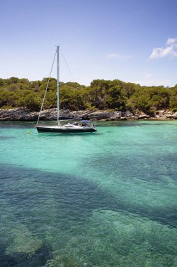 Menorca Adası, Akdeniz, İspanya 'da Cala Macarelleta' da bir yat duruyor.