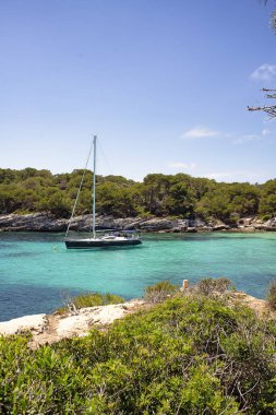 Menorca Adası, Akdeniz, İspanya 'da Cala Macarelleta' da bir yat duruyor.