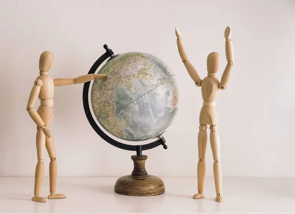 Wooden figures choosing travel destination on a world map. Travel lifestyle happiness moments