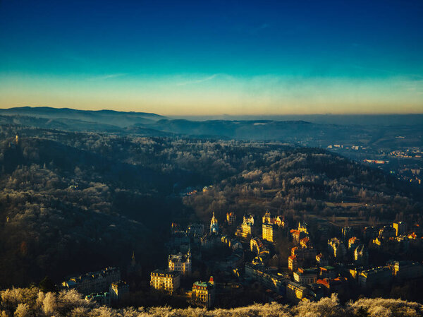 Aerial view of Pine trees forest on cold winter morning with early warm sunlight european city