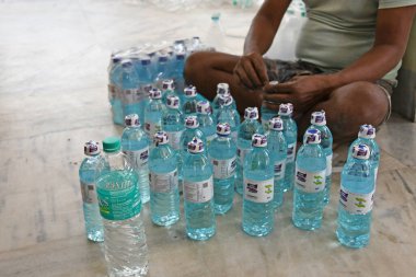 Burdwan, Purba Bardhaman Bölgesi, Batı Bengal / Hindistan - 19.04.2020: Burdwan merkezli kuruluş 'Palla Yolu Pallimongal Samity' Kamu Özel Ortaklığı projesinde alkol bazlı el dezenfektanları üretiyor.