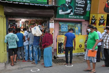 Burdwan, Batı Bengal / Hindistan - 04.05.2020: Roman Coronavirus (COVID-19) salgını nedeniyle hükümet talimatlarının açıklanmasının ardından likör dükkanı olarak uzun kuyruklar yeniden açıldı.