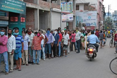 Burdwan, Batı Bengal / Hindistan - 04.05.2020: Roman Coronavirus (COVID-19) salgını nedeniyle hükümet talimatlarının açıklanmasının ardından likör dükkanı olarak uzun kuyruklar yeniden açıldı.