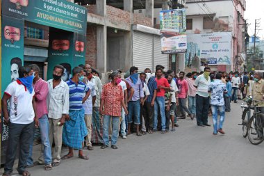 Burdwan, Batı Bengal / Hindistan - 04.05.2020: Roman Coronavirus (COVID-19) salgını nedeniyle hükümet talimatlarının açıklanmasının ardından likör dükkanı olarak uzun kuyruklar yeniden açıldı.