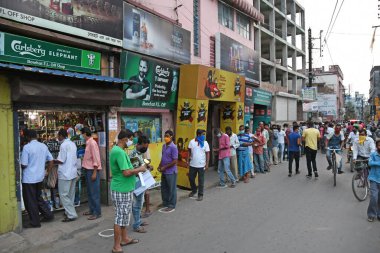 Burdwan, Batı Bengal / Hindistan - 04.05.2020: Roman Coronavirus (COVID-19) salgını nedeniyle hükümet talimatlarının açıklanmasının ardından likör dükkanı olarak uzun kuyruklar yeniden açıldı.