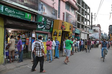 Burdwan, Batı Bengal / Hindistan - 04.05.2020: Roman Coronavirus (COVID-19) salgını nedeniyle hükümet talimatlarının açıklanmasının ardından likör dükkanı olarak uzun kuyruklar yeniden açıldı.