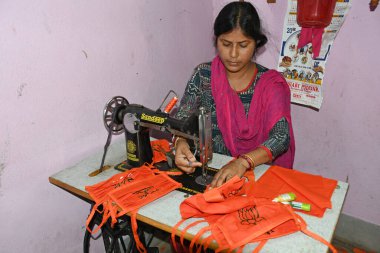 Burdwan Town, Purba Bardhaman Bölgesi, Batı Bengal / Hindistan - 10.05.2020: Burdwan Kasabası 'ndaki yerel bir BJP (Bharatiya Janata Partisi) lideri, parti destekçilerinin Novel Coronavirus' u (COVID-19) önlemek için maske yapıyor)