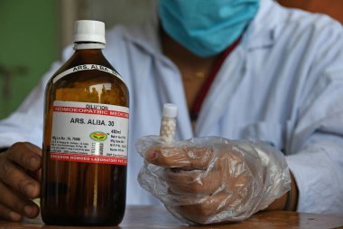 Burdwan, Batı Bengal / Hindistan - 14.05.2020: Homeopatik tıp 'Arsenicum Album 30', Hindistan Hükümeti AYUSH yönetimi altında Novel Coronavirus 'a (COVID-19) karşı dokunulmazlığı artırmak için ücretsiz olarak dağıtılıyor.