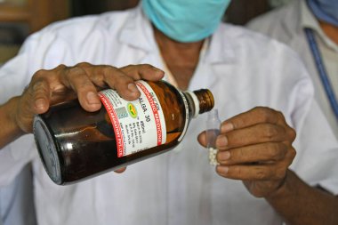 Burdwan, Batı Bengal / Hindistan - 14.05.2020: Homeopatik tıp 'Arsenicum Album 30', Hindistan Hükümeti AYUSH yönetimi altında Novel Coronavirus 'a (COVID-19) karşı dokunulmazlığı artırmak için ücretsiz olarak dağıtılıyor.