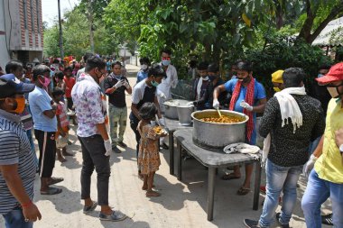 Burdwan Town, Purba Bardhaman İlçesi, Batı Bengal / Hindistan - 17.05.2020: Roman Coronavirus 'un (COVID-19) ortaya çıkmasından dolayı para kazanamayan aile üyelerine pişirilmiş yiyecekler veriliyor. Burdwan Kasabasında.