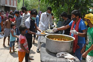 Burdwan Town, Purba Bardhaman İlçesi, Batı Bengal / Hindistan - 17.05.2020: Roman Coronavirus 'un (COVID-19) ortaya çıkmasından dolayı para kazanamayan aile üyelerine pişirilmiş yiyecekler veriliyor. Burdwan Kasabasında.