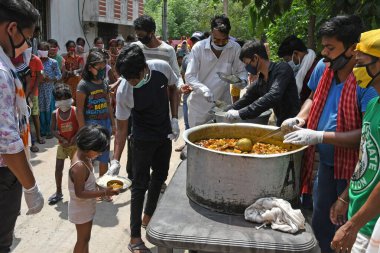Burdwan Town, Purba Bardhaman İlçesi, Batı Bengal / Hindistan - 17.05.2020: Roman Coronavirus 'un (COVID-19) ortaya çıkmasından dolayı para kazanamayan aile üyelerine pişirilmiş yiyecekler veriliyor. Burdwan Kasabasında.