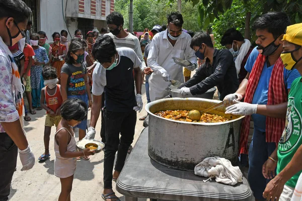 Burdwan Town, Purba Bardhaman İlçesi, Batı Bengal / Hindistan - 17.05.2020: Roman Coronavirus 'un (COVID-19) ortaya çıkmasından dolayı para kazanamayan aile üyelerine pişirilmiş yiyecekler veriliyor. Burdwan Kasabasında.