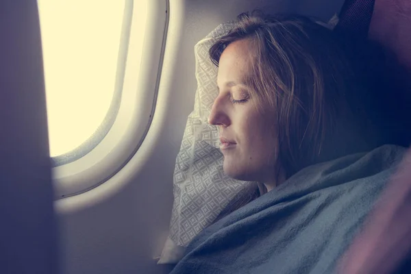 Vrouwelijke passagier slapen bedekt met deken. — Stockfoto