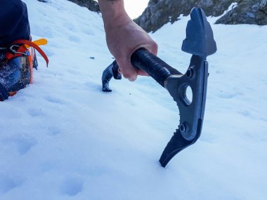 Closeup of ice axe on steep slope. clipart