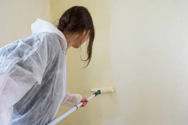Joven estudiante mujer pintando su habitación . — Foto de Stock
