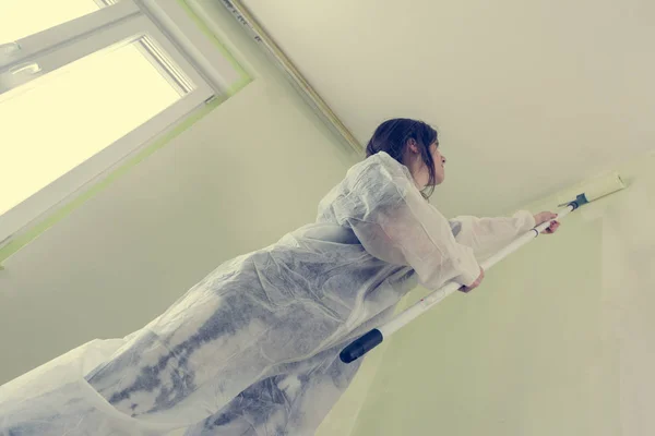 Joven estudiante mujer pintando su habitación . — Foto de Stock