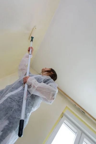 Joven estudiante mujer pintando su habitación . — Foto de Stock