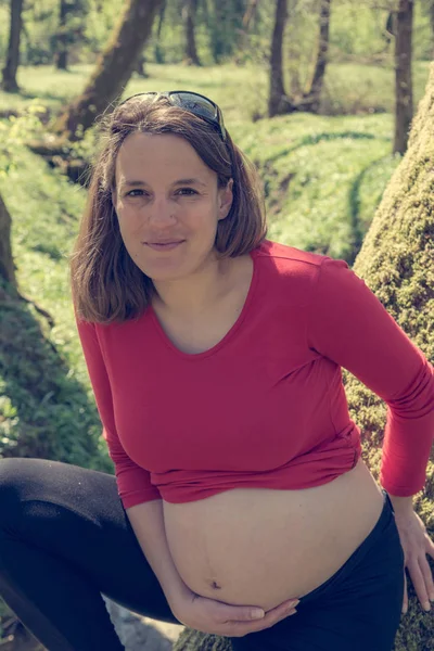 Mujer embarazada joven posando en el parque . —  Fotos de Stock