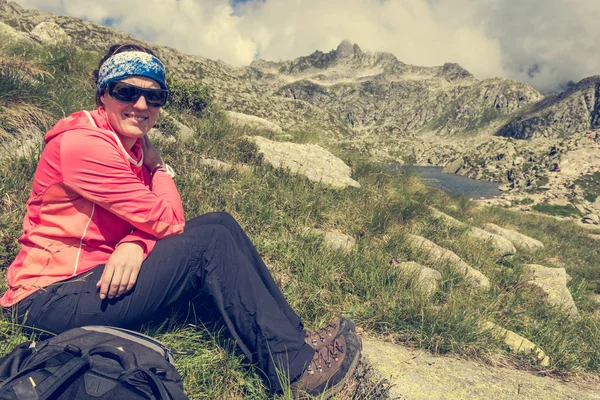 Kadın trekker dağ çayır üzerinde dinlenme. — Stok fotoğraf