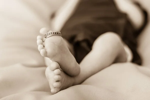 Primer plano de los pies recién nacidos con un anillo de bodas . — Foto de Stock
