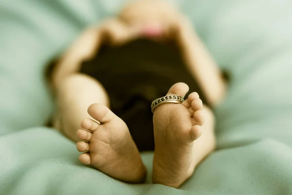 Gros plan de pieds nouveau-nés avec une bague de mariage . — Photo