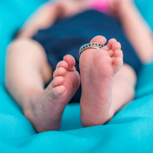 Closeup novorozence nohou s snubní prsten. — Stock fotografie