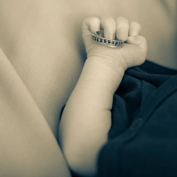 Novorozence drží snubní prsten. — Stock fotografie