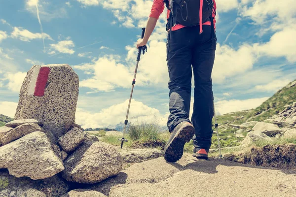 Wanderer passiert weißes und rotes Wegweiser. — Stockfoto