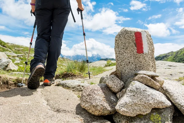 Hiker passing white and red trail sign. — Stock Photo, Image