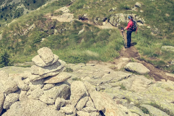 Hiker passing a stone pyramide. — Stock Photo, Image