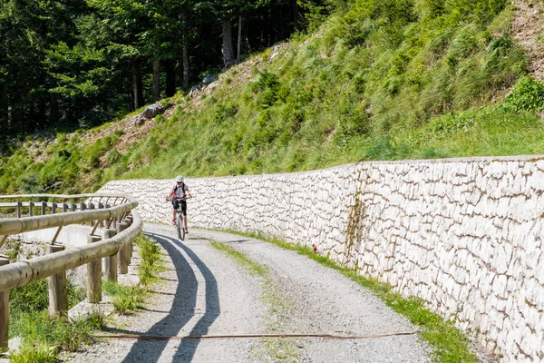 急な道に取り組む魅力的な女性サイクリスト. — ストック写真