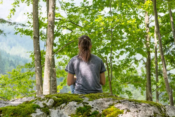 Jovem mulher meditando na rocha da floresta . — Fotografia de Stock