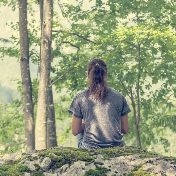 Jonge vrouw mediteren op bos rots. — Stockfoto