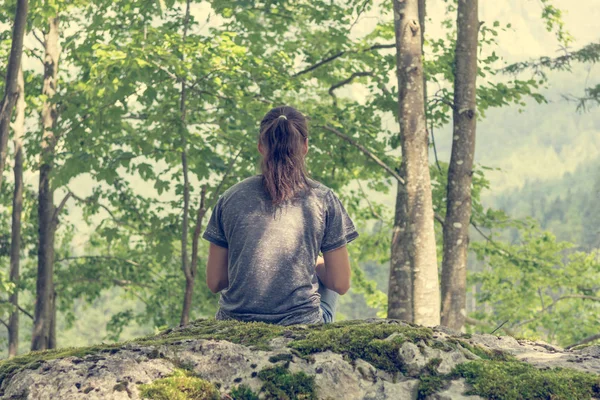 Junge Frau meditiert auf Waldfelsen. — Stockfoto