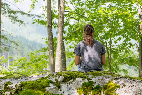 Jonge vrouw mediteren op bos rots. — Stockfoto