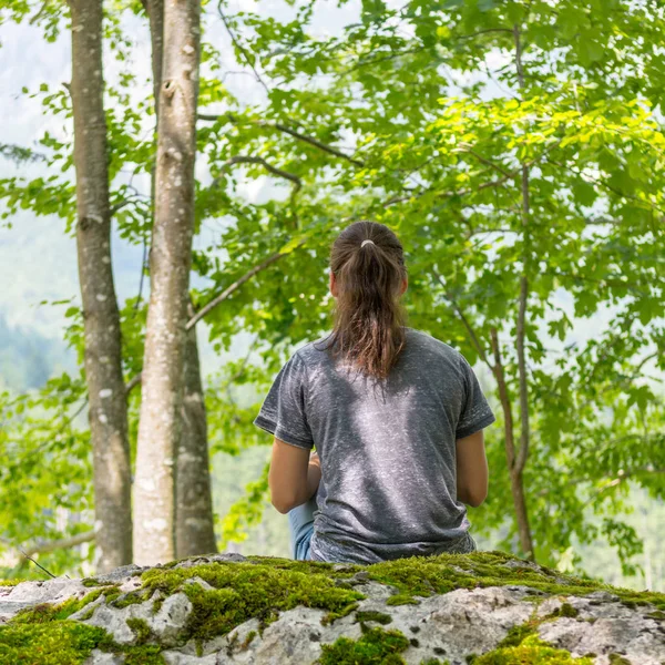 Genç kadın orman kayanın üzerinde meditasyon. — Stok fotoğraf