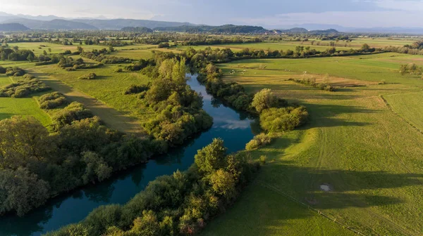 Aerial view of river bending across fields at sunset. — Stock Photo, Image