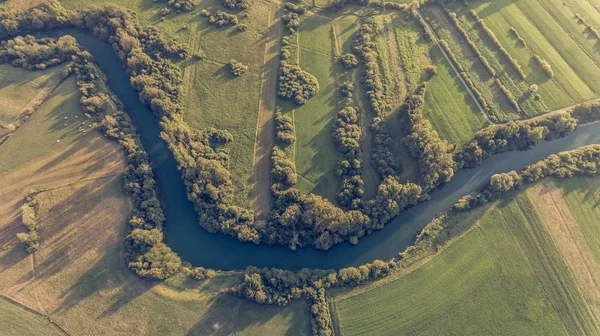 River bend surrounded by fields from birds eye view. — Stock Photo, Image