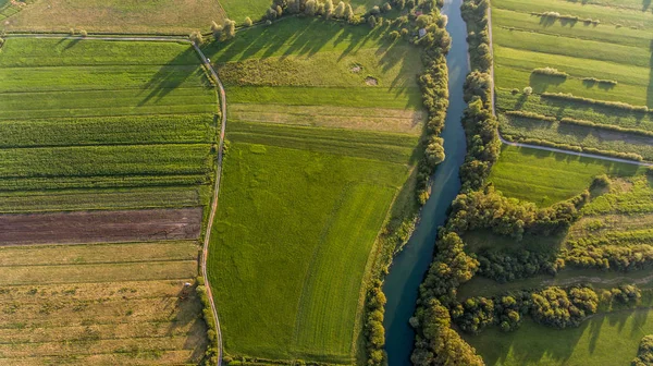 Поворот реки в окружении полей с высоты птичьего полета . — стоковое фото
