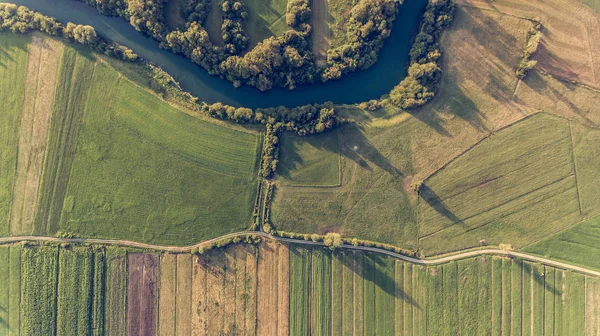 River bend surrounded by fields from birds eye view. — Stock Photo, Image