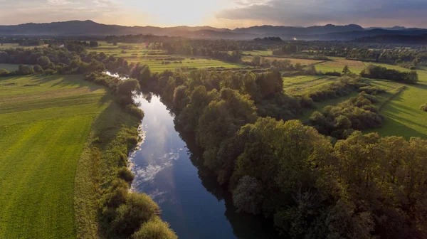 Aerial view of river bending across fields at sunset. — Stock Photo, Image