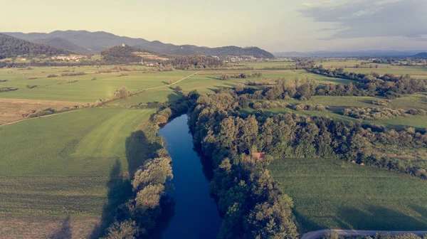 Aerial view of river bending across fields at sunset. — Stock Photo, Image