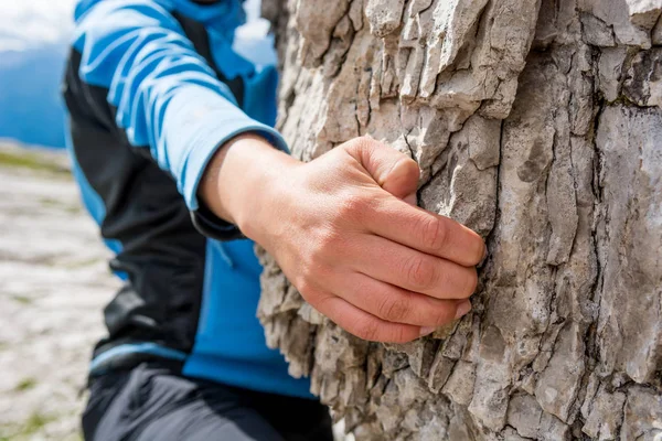 Closeup of female hand rock climbing.