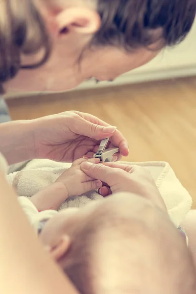 Matka, jemně řezání nehty baby. — Stock fotografie